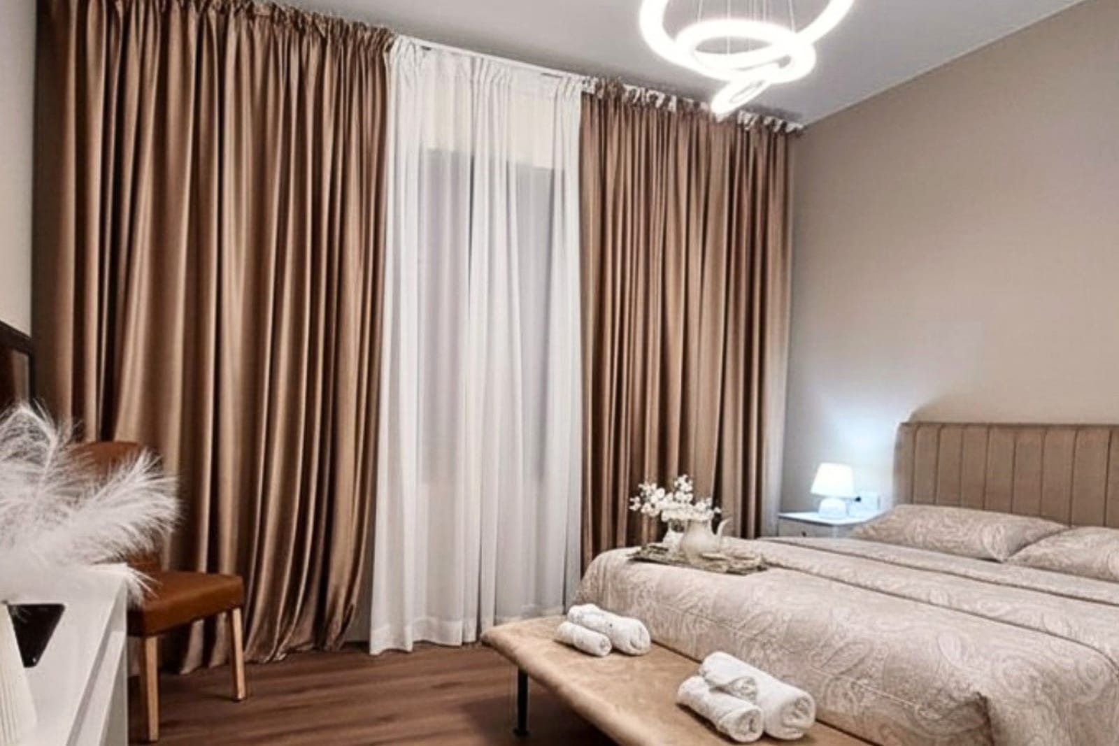 Camera matrimoniale luminosa con letto king size e tende eleganti a Perla Toscana